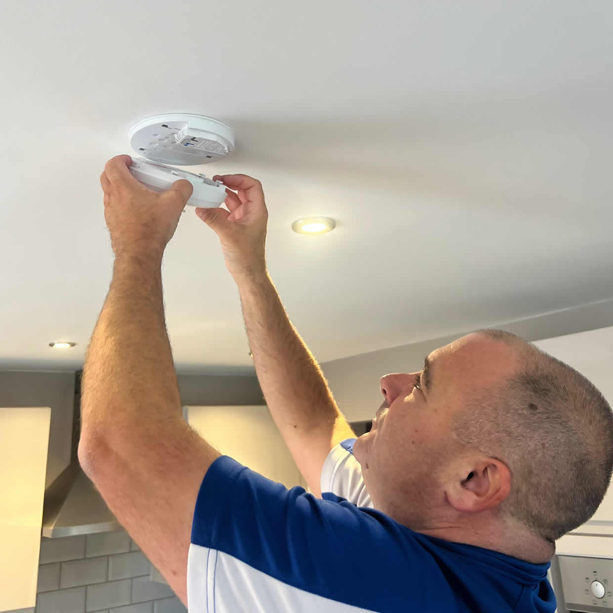 Smoke alarm being installed on a ceiling in Bacup